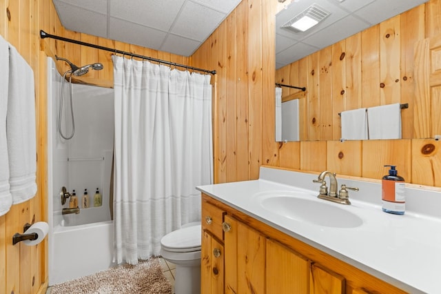 full bathroom with wooden walls, vanity, toilet, tile patterned floors, and shower / bath combo with shower curtain