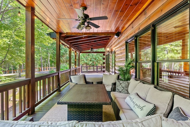 wooden deck with outdoor lounge area, covered porch, and ceiling fan