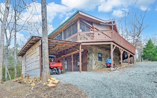 530 Bear Paw Church Rd, Murphy, NC 28906 - view of home's exterior with a deck, stone siding, gravel driveway, and a sunroom
