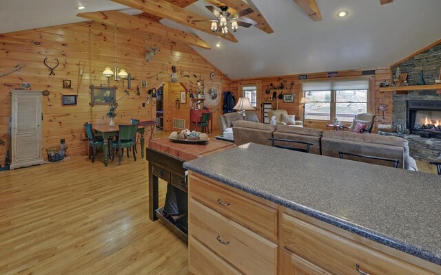 530 Bear Paw Church Rd, Murphy, NC 28906 - kitchen with light wood finished floors, dark countertops, lofted ceiling with beams, open floor plan, and a stone fireplace