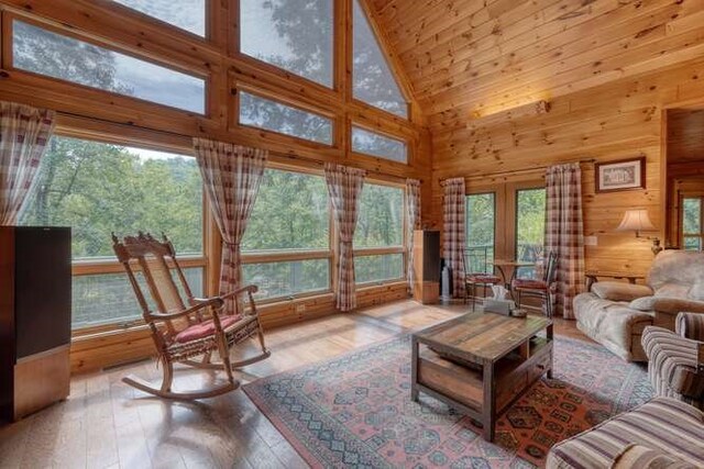 living room with high vaulted ceiling, plenty of natural light, hardwood / wood-style floors, and ceiling fan