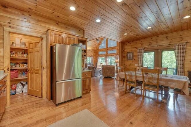 living room featuring hardwood / wood-style floors, high vaulted ceiling, and wooden walls