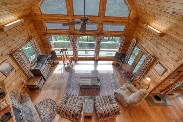 bedroom featuring ceiling fan, wooden walls, french doors, and access to outside