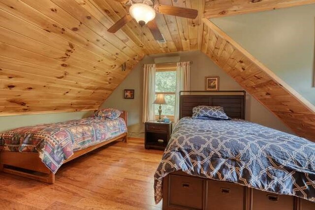 bedroom with wood walls, ceiling fan, wooden ceiling, and carpet floors