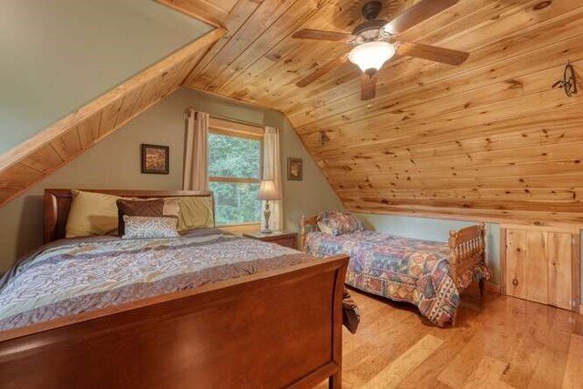 carpeted bedroom with ceiling fan, wooden walls, and wooden ceiling