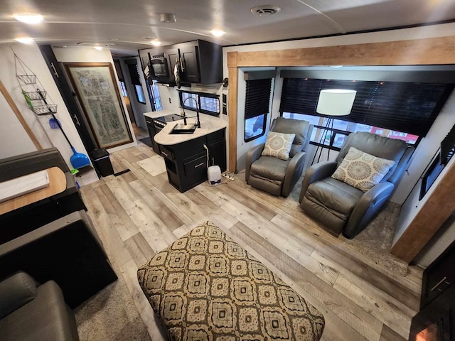 living area with light wood finished floors and visible vents