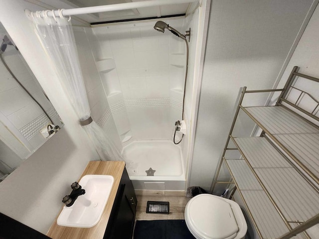 bathroom featuring a stall shower, tile patterned flooring, a sink, and toilet