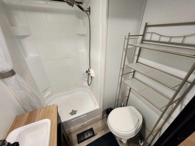 bathroom featuring visible vents, a stall shower, and toilet