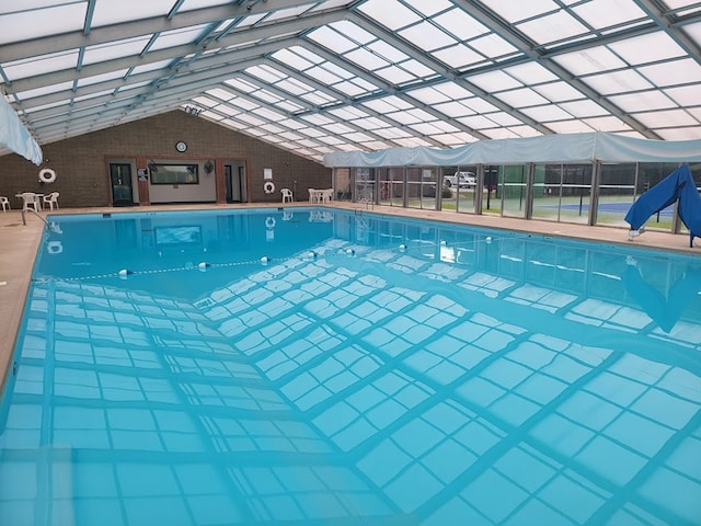 community pool with a patio area and glass enclosure