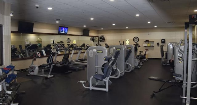 exercise room with a paneled ceiling and recessed lighting