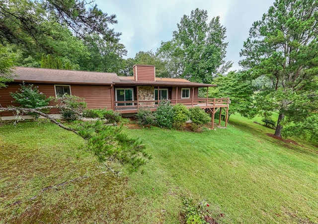 back of house with a deck and a yard