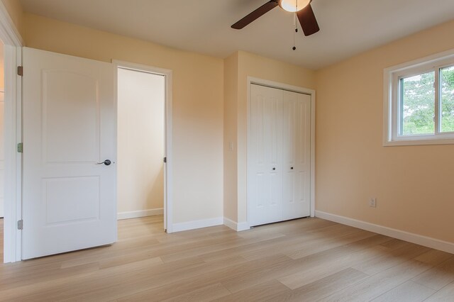 unfurnished bedroom featuring ceiling fan, light hardwood / wood-style floors, and a closet