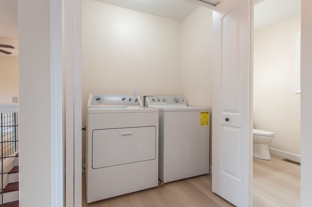 clothes washing area with separate washer and dryer, ceiling fan, and light wood-type flooring