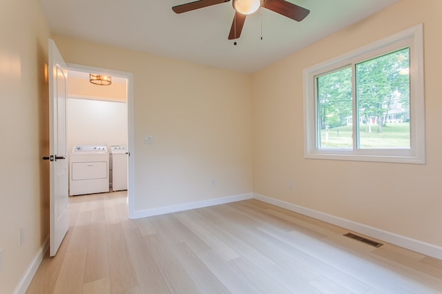 spare room featuring light hardwood / wood-style floors, separate washer and dryer, and ceiling fan