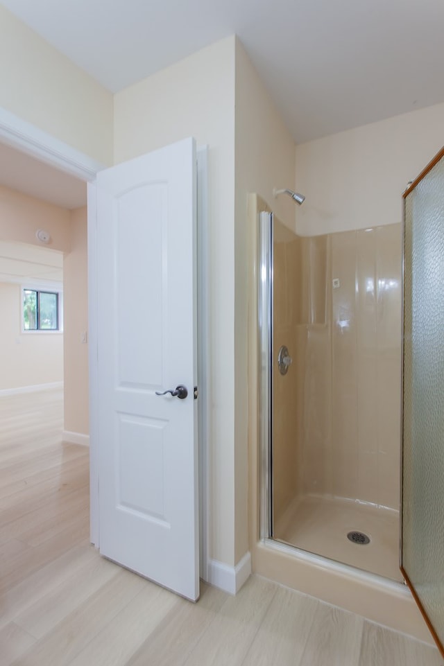 bathroom with walk in shower and hardwood / wood-style floors