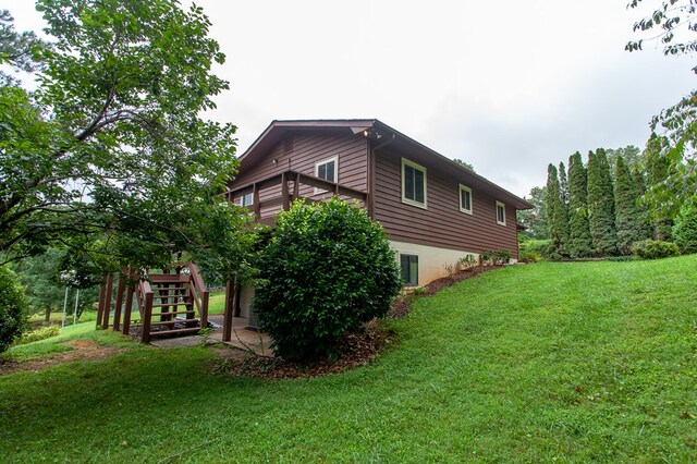 view of home's exterior with a wooden deck and a yard