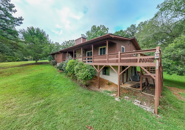 rear view of house with a wooden deck and a lawn