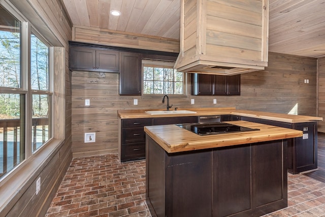 kitchen featuring a kitchen island, butcher block counters, sink, dark brown cabinets, and black electric cooktop