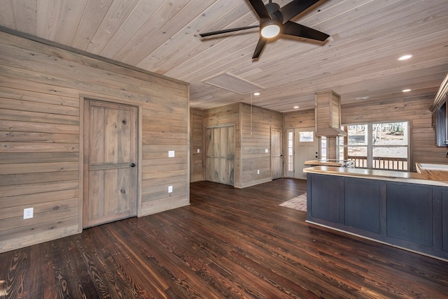 kitchen with ceiling fan, dark wood-type flooring, wood ceiling, and wood walls