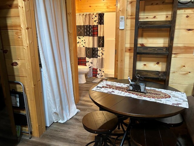 dining room featuring wood walls and dark hardwood / wood-style flooring