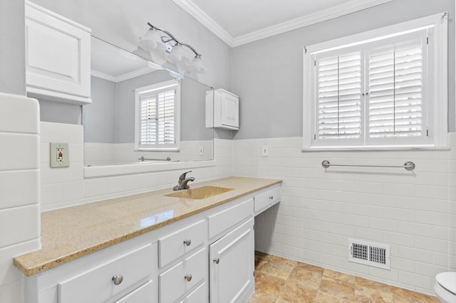 bathroom with tile walls, ornamental molding, and vanity