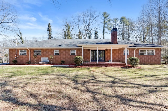 rear view of property featuring a lawn