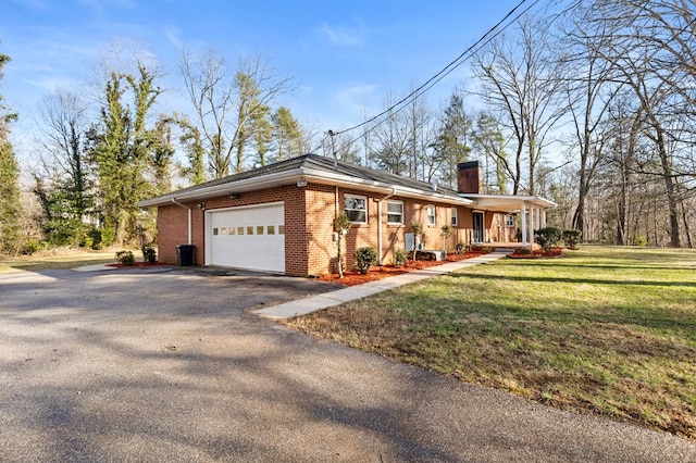 exterior space featuring a garage, covered porch, and a front yard