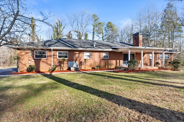 rear view of house featuring a yard and a porch