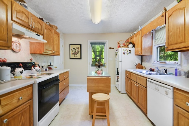 kitchen with backsplash, white appliances, sink, and a textured ceiling