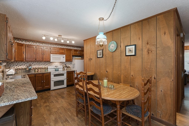 dining room featuring dark hardwood / wood-style flooring, sink, and a textured ceiling