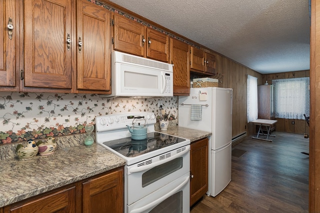 kitchen with a textured ceiling, dark wood-type flooring, and white appliances