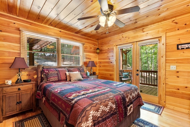 bedroom with access to outside, light hardwood / wood-style flooring, wood walls, wood ceiling, and ceiling fan