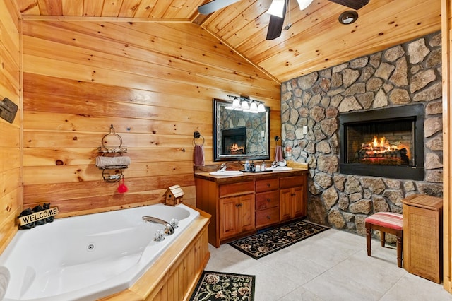 bathroom with wood ceiling, a tub to relax in, vaulted ceiling, tile patterned floors, and a fireplace