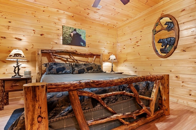 bedroom with wood walls, ceiling fan, light hardwood / wood-style flooring, and wood ceiling