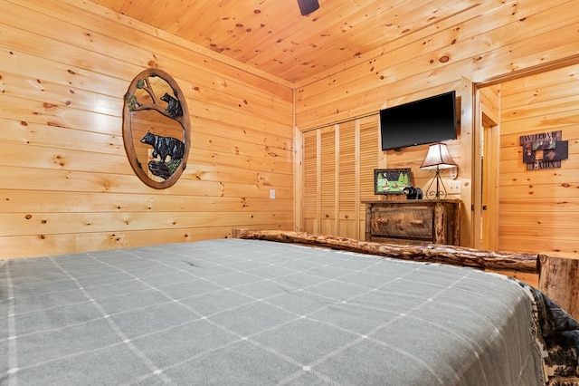 bedroom with wooden walls, a closet, and wood ceiling