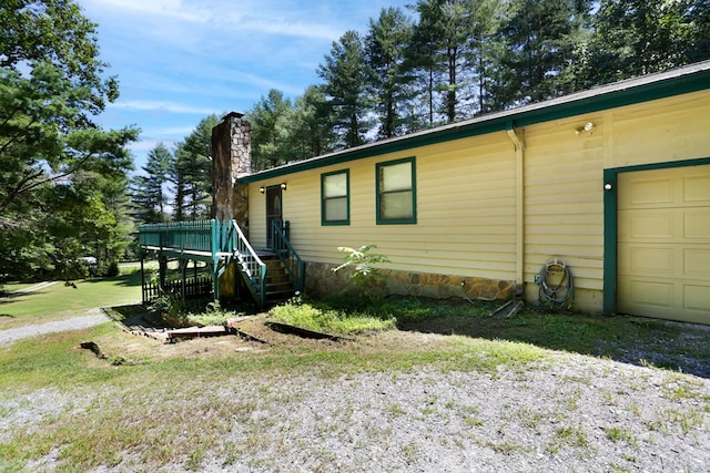 view of property exterior with a garage and a lawn