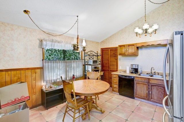 kitchen featuring stainless steel refrigerator, wooden walls, dishwasher, sink, and vaulted ceiling