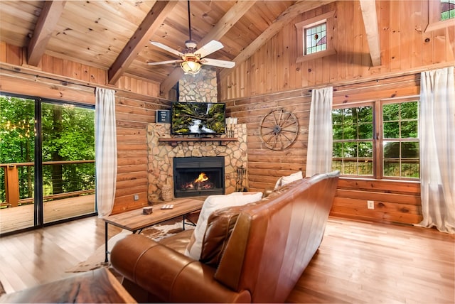 living room featuring a stone fireplace, rustic walls, wood ceiling, light wood-type flooring, and beamed ceiling