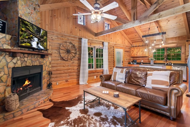 living room with beam ceiling, a fireplace, wood finished floors, and wooden ceiling