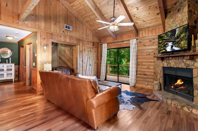 living room featuring visible vents, wooden ceiling, wood finished floors, a fireplace, and beam ceiling