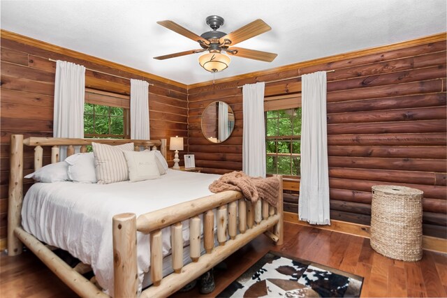 bedroom featuring crown molding, wooden walls, ceiling fan, and a closet