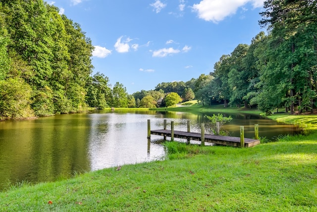 view of dock with a water view and a yard