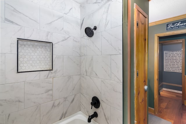 full bath featuring shower / bath combination, crown molding, and wood finished floors