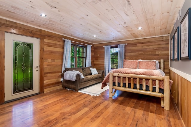 bedroom with wood walls, wood ceiling, access to outside, and wood finished floors