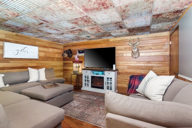 living room with light hardwood / wood-style flooring and wood walls