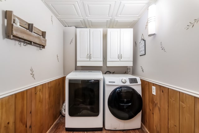 laundry room featuring cabinet space, wood walls, and wainscoting