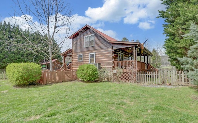 back of house featuring fence, a lawn, and covered porch