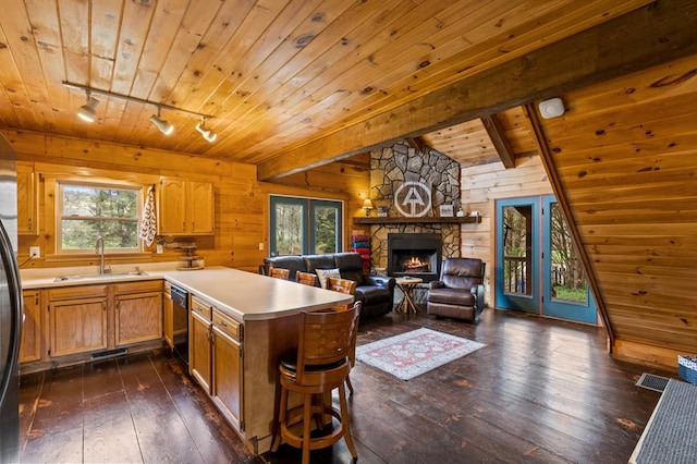 kitchen with rail lighting, a peninsula, black dishwasher, wooden ceiling, and a sink