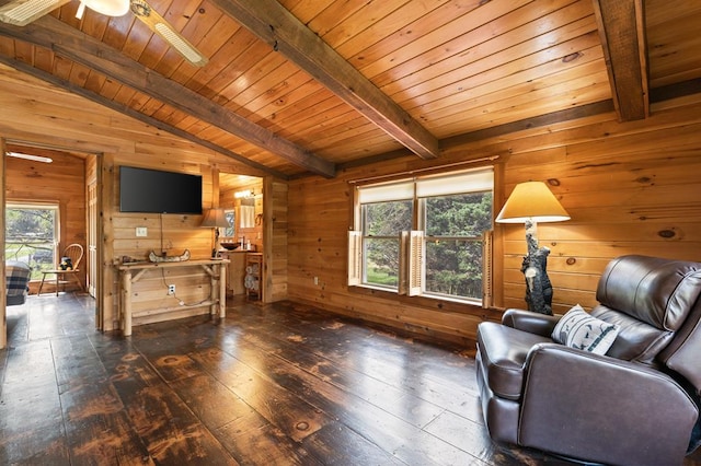 sitting room featuring wood walls, lofted ceiling with beams, a wealth of natural light, and dark wood-style flooring