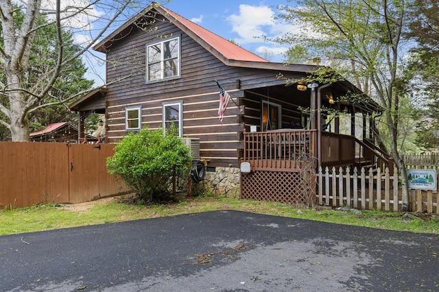 exterior space featuring a porch and fence